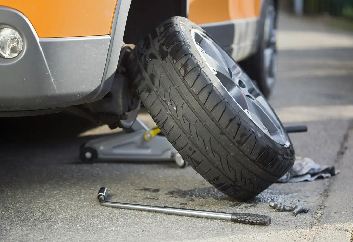 zdjęte koło oparte o auto